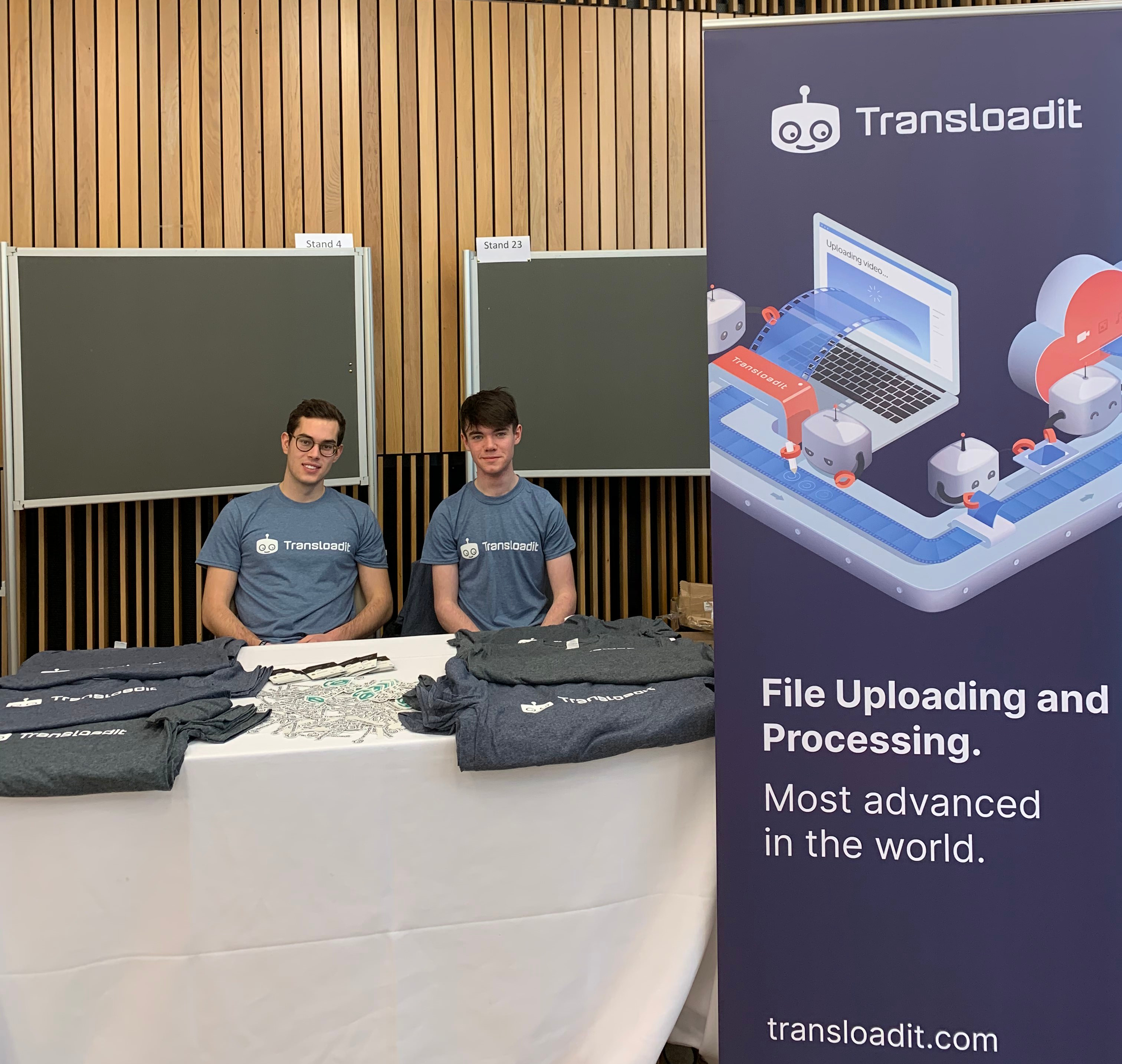 Marius and Charlie at the Q&A panel with Transloadit swag on a table in front of them.